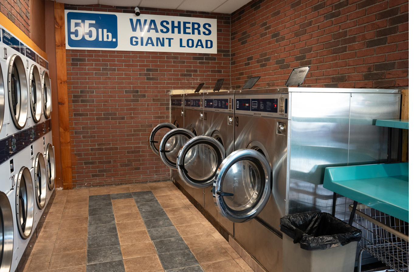 55 lb. giant load Dexter washing machines with sign overhead
